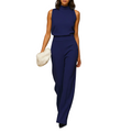 woman wearing sleeveless halter jumpsuit with high waist and wide leg design standing in a full outfit front view